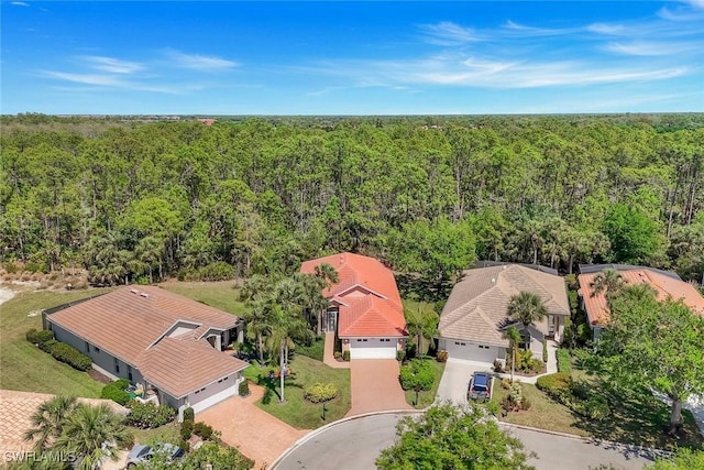 drone / aerial view featuring a forest view and a residential view