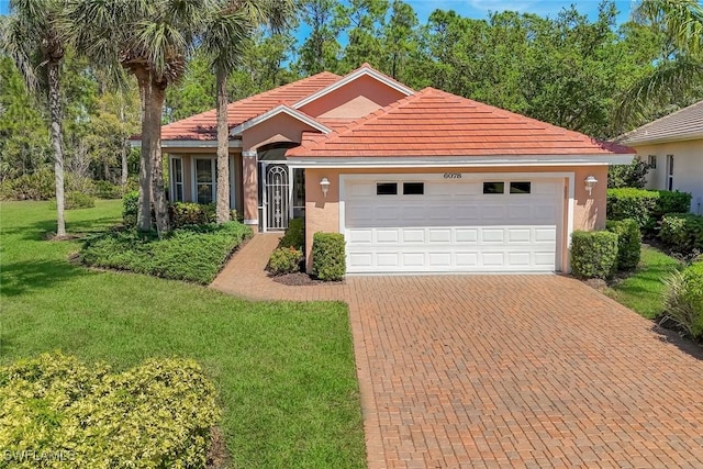view of front of property featuring stucco siding, decorative driveway, an attached garage, a front yard, and a tiled roof
