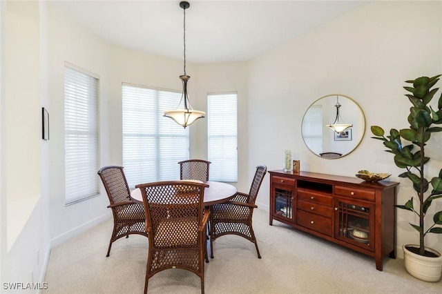 dining room featuring baseboards and light carpet