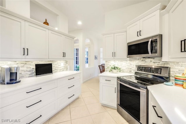 kitchen featuring light tile patterned floors, white cabinets, recessed lighting, appliances with stainless steel finishes, and decorative backsplash