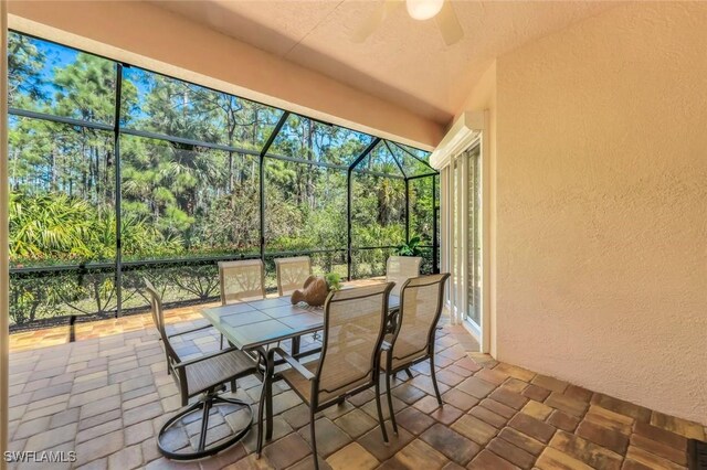 sunroom featuring outdoor dining space, a ceiling fan, and plenty of natural light