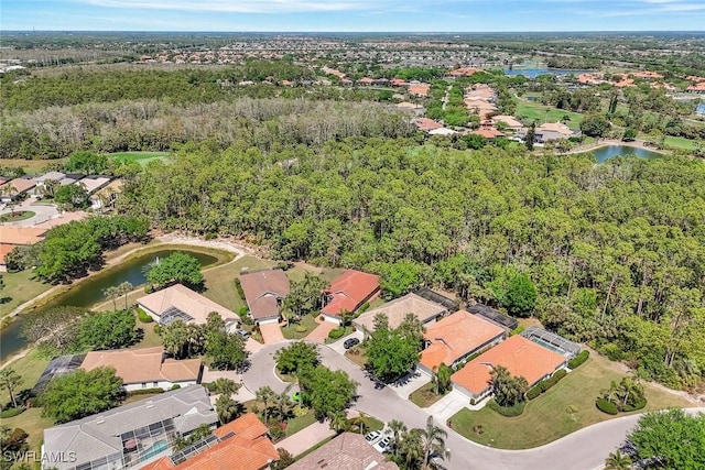 aerial view featuring a water view, a wooded view, and a residential view