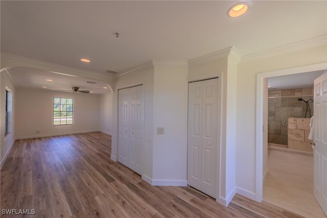 20587 Charing Cross Cir, Estero, FL 33928 - unfurnished bedroom featuring arched walkways, multiple closets, crown molding, light wood-type flooring, and baseboards