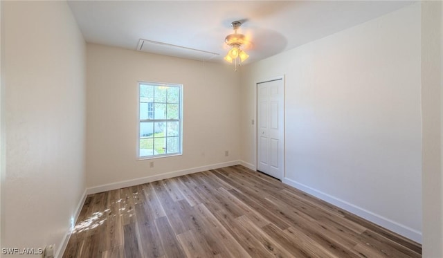 20587 Charing Cross Cir, Estero, FL 33928 - empty room featuring attic access, wood finished floors, baseboards, and ceiling fan