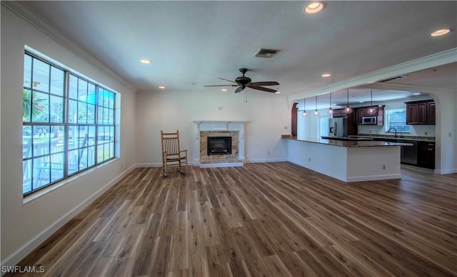 20587 Charing Cross Cir, Estero, FL 33928 - unfurnished living room with ceiling fan, ornamental molding, wood finished floors, recessed lighting, and a glass covered fireplace