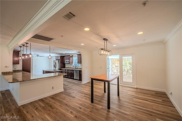 20587 Charing Cross Cir, Estero, FL 33928 - kitchen featuring stainless steel appliances, ornamental molding, a chandelier, a peninsula, and a sink