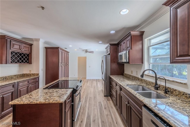 20587 Charing Cross Cir, Estero, FL 33928 - kitchen with appliances with stainless steel finishes, a sink, a kitchen island, light wood-type flooring, and light stone countertops