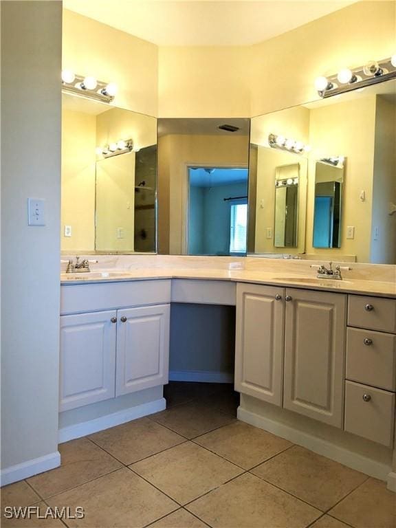 bathroom with tile patterned floors, vanity, and baseboards
