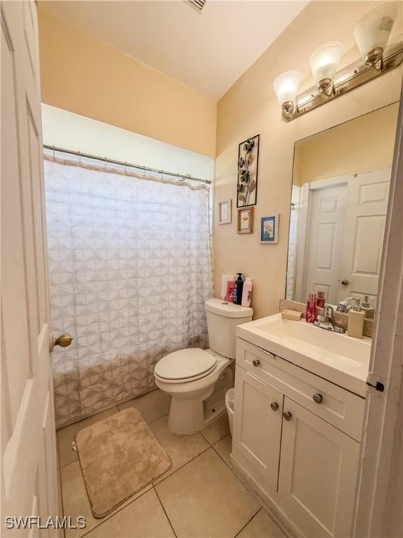 3911 9th St SW, Lehigh Acres, FL 33976 - full bath featuring toilet, a shower with curtain, tile patterned flooring, and vanity