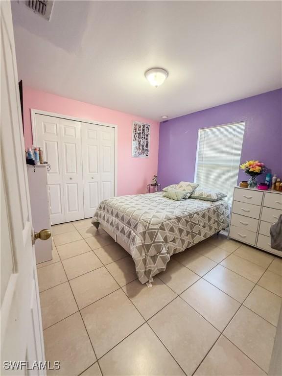 3911 9th St SW, Lehigh Acres, FL 33976 - bedroom featuring visible vents, light tile patterned floors, and a closet