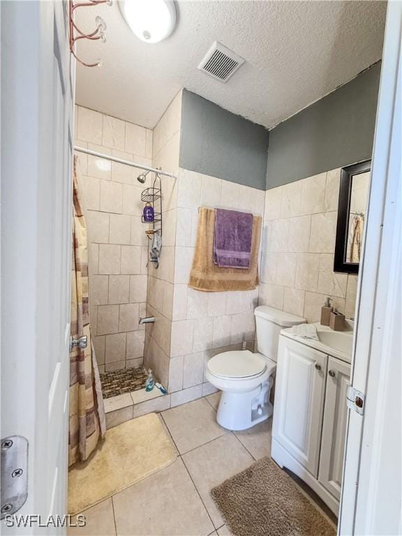 3911 9th St SW, Lehigh Acres, FL 33976 - full bath featuring a tile shower, vanity, tile patterned floors, tile walls, and visible vents