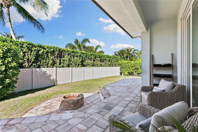 view of patio with a fenced backyard and a fire pit