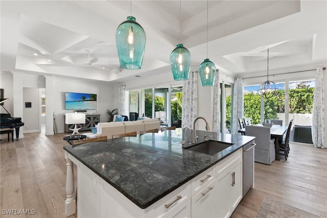 kitchen with plenty of natural light, a sink, a raised ceiling, and coffered ceiling