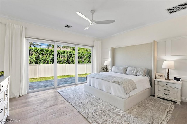 bedroom featuring light wood-type flooring, visible vents, ornamental molding, and access to exterior