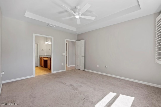 6068 Triumph Ln, Ave Maria, FL 34142 - unfurnished bedroom with visible vents, baseboards, light carpet, ensuite bathroom, and a raised ceiling