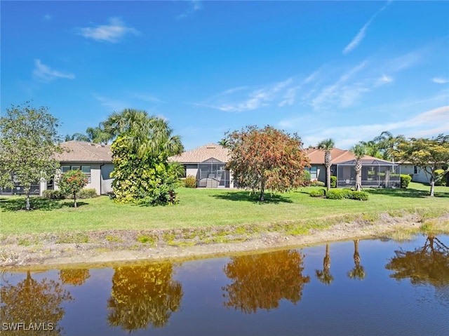 6068 Triumph Ln, Ave Maria, FL 34142 - rear view of house featuring a lanai, a lawn, and a water view