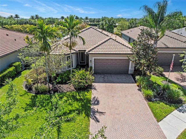 6068 Triumph Ln, Ave Maria, FL 34142 - view of front of property featuring a garage, decorative driveway, stucco siding, and a tile roof