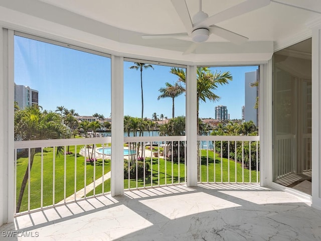unfurnished sunroom with a water view and ceiling fan