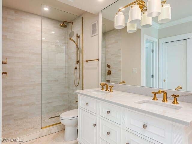 full bath featuring ornamental molding, tiled shower, visible vents, and a sink
