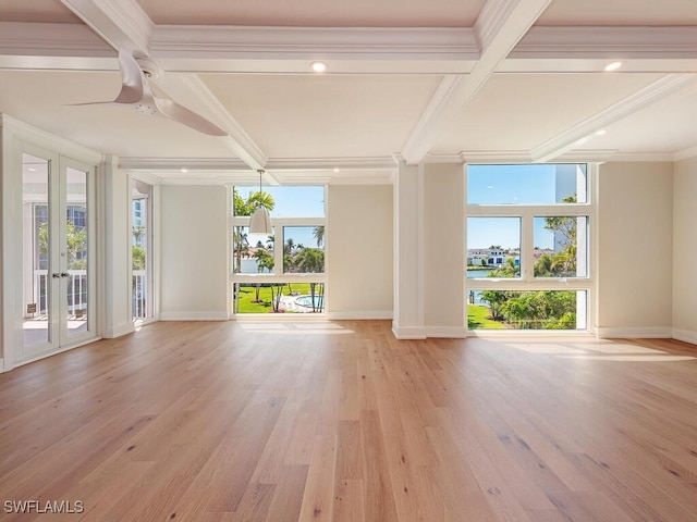 unfurnished room featuring beamed ceiling, plenty of natural light, light wood-type flooring, and ornamental molding
