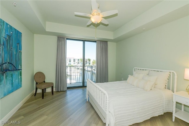 1490 5th Ave S Unit 200B, Naples, FL 34102 - bedroom featuring access to outside, wood finished floors, baseboards, a raised ceiling, and a ceiling fan