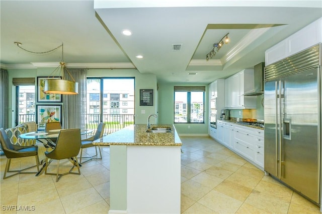 1490 5th Ave S Unit 200B, Naples, FL 34102 - kitchen with appliances with stainless steel finishes, a sink, ornamental molding, a raised ceiling, and wall chimney range hood