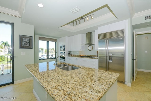 1490 5th Ave S Unit 200B, Naples, FL 34102 - kitchen featuring built in appliances, a sink, wall chimney exhaust hood, light tile patterned floors, and ornamental molding