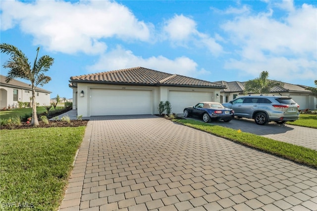 19513 Hinkley Dr, Estero, FL 33928 - view of front of house featuring stucco siding, an attached garage, a tiled roof, decorative driveway, and a front yard