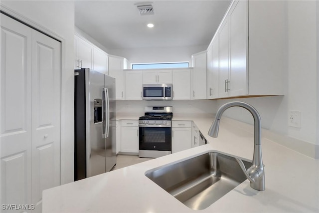 19513 Hinkley Dr, Estero, FL 33928 - kitchen with light countertops, stainless steel appliances, a sink, visible vents, and white cabinets