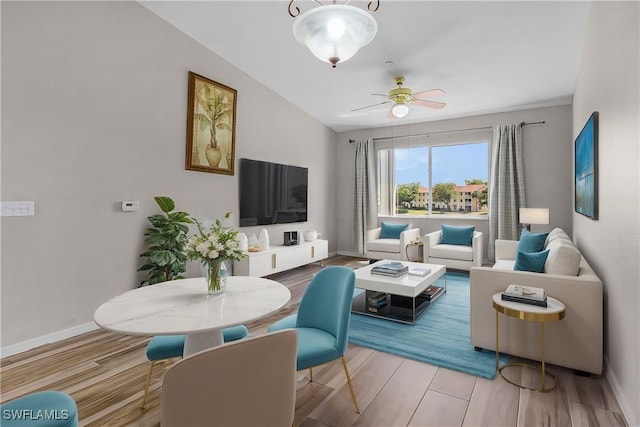 living area with ceiling fan, wood finished floors, and baseboards