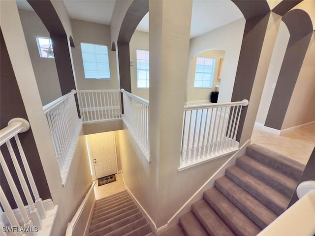 5956 Tarpon Gardens Cir Unit 201, Cape Coral, FL 33914 - stairs with baseboards, arched walkways, and a high ceiling