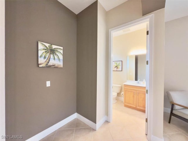 5956 Tarpon Gardens Cir Unit 201, Cape Coral, FL 33914 - hallway featuring light tile patterned flooring, baseboards, and a sink
