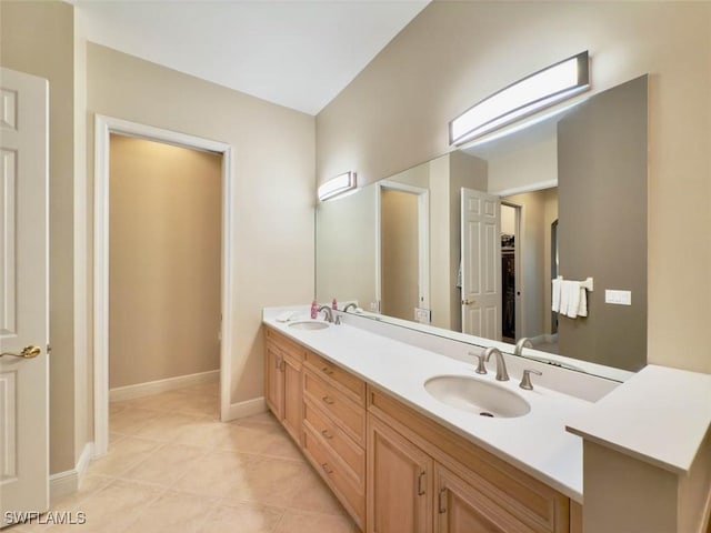 5956 Tarpon Gardens Cir Unit 201, Cape Coral, FL 33914 - bathroom featuring tile patterned flooring, double vanity, baseboards, and a sink