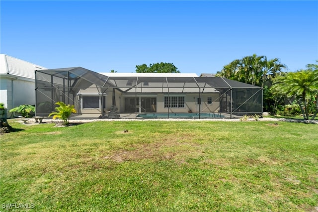 rear view of house with a lanai, a lawn, an outdoor pool, and stucco siding