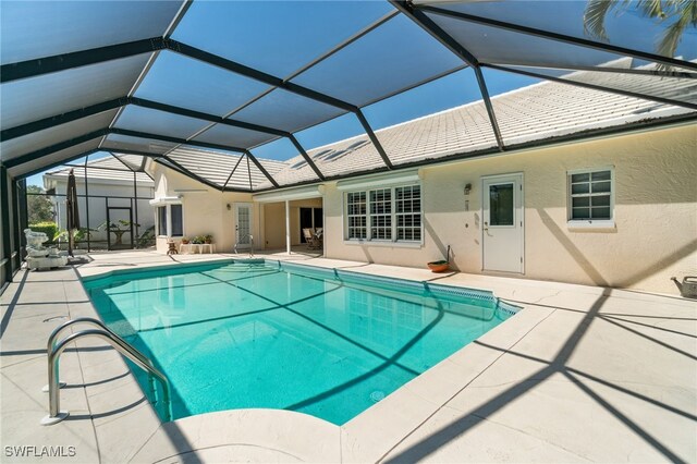 outdoor pool with glass enclosure and a patio