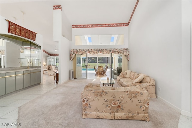 tiled living room featuring baseboards, a high ceiling, carpet, and a sink