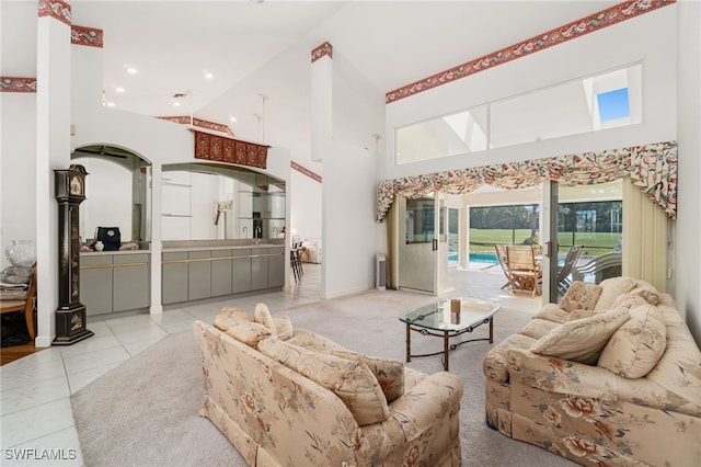 living room with light tile patterned floors, recessed lighting, and a high ceiling