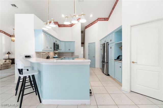 kitchen featuring blue cabinets, visible vents, appliances with stainless steel finishes, and a peninsula