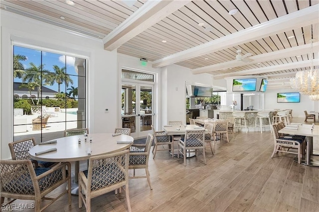 dining space featuring beam ceiling, french doors, wood finished floors, and wooden ceiling