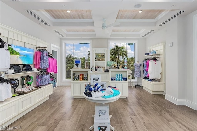 interior space featuring beam ceiling, ornamental molding, coffered ceiling, wood finished floors, and ceiling fan
