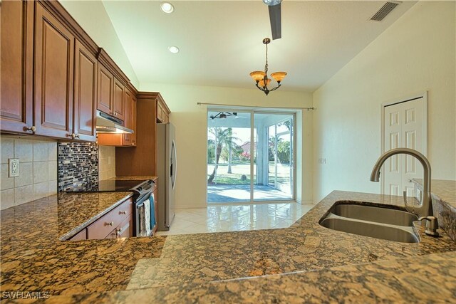 1675 Blue Lake Cir, Punta Gorda, FL 33983 - kitchen with stainless steel appliances, decorative backsplash, vaulted ceiling, a sink, and under cabinet range hood