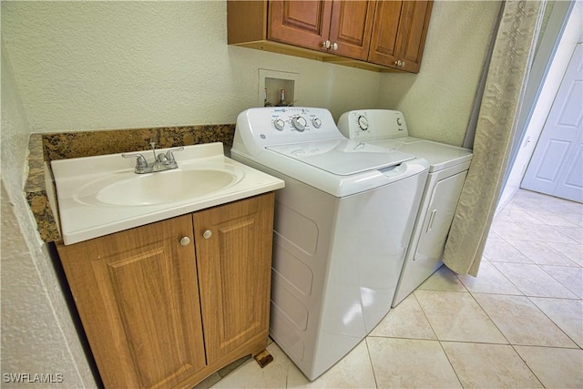1675 Blue Lake Cir, Punta Gorda, FL 33983 - clothes washing area featuring washing machine and clothes dryer, light tile patterned flooring, cabinet space, a sink, and a textured wall