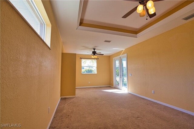 1675 Blue Lake Cir, Punta Gorda, FL 33983 - carpeted spare room with a ceiling fan, visible vents, baseboards, a tray ceiling, and a textured wall