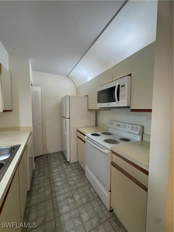177 Santa Clara Dr Unit 177-5, Naples, FL 34104 - kitchen with white appliances, light countertops, lofted ceiling, a sink, and light floors