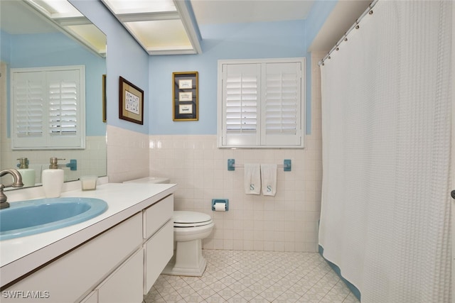 15440 Kilmarnock Dr, Fort Myers, FL 33912 - full bathroom featuring tile walls, a wainscoted wall, toilet, tile patterned floors, and vanity