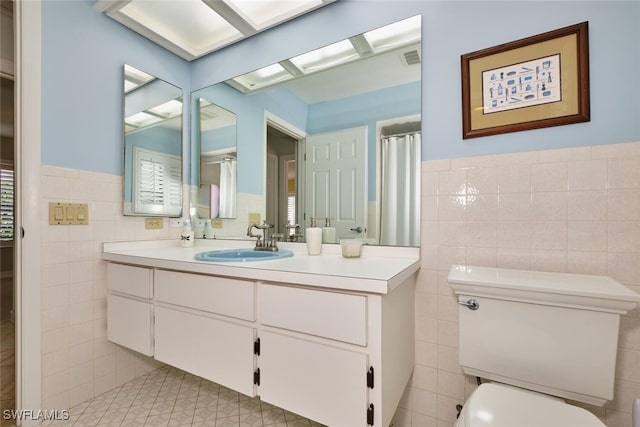 15440 Kilmarnock Dr, Fort Myers, FL 33912 - full bath featuring vanity, tile walls, toilet, a wainscoted wall, and visible vents