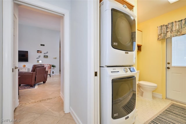 15440 Kilmarnock Dr, Fort Myers, FL 33912 - clothes washing area featuring stacked washer and dryer, baseboards, laundry area, and light tile patterned flooring