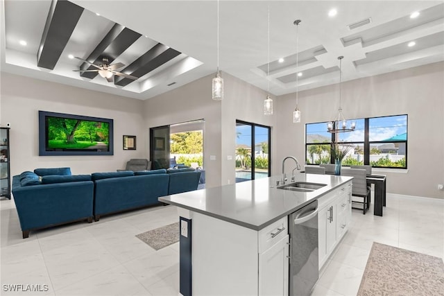 kitchen with coffered ceiling, a sink, stainless steel dishwasher, a kitchen island with sink, and a towering ceiling