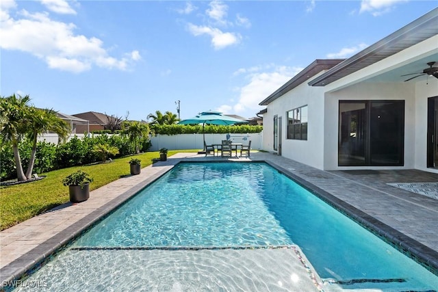 view of swimming pool featuring a patio, a fenced backyard, a fenced in pool, a ceiling fan, and a yard
