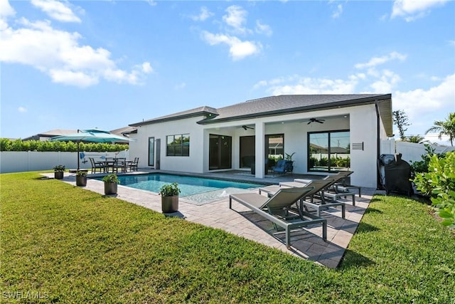 back of property featuring stucco siding, a patio, a fenced backyard, outdoor dining area, and a lawn